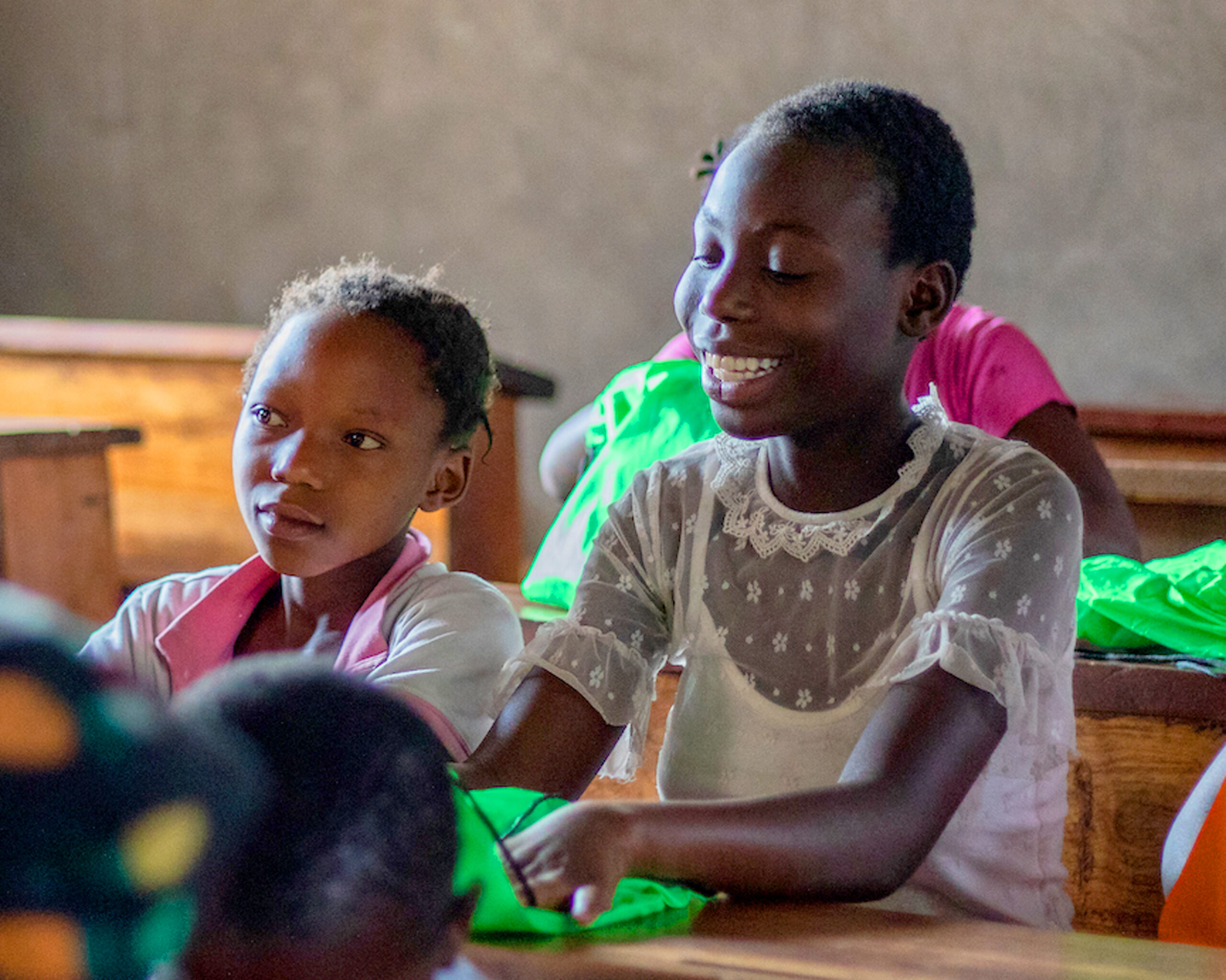 African girl sitting at a school desk smiling